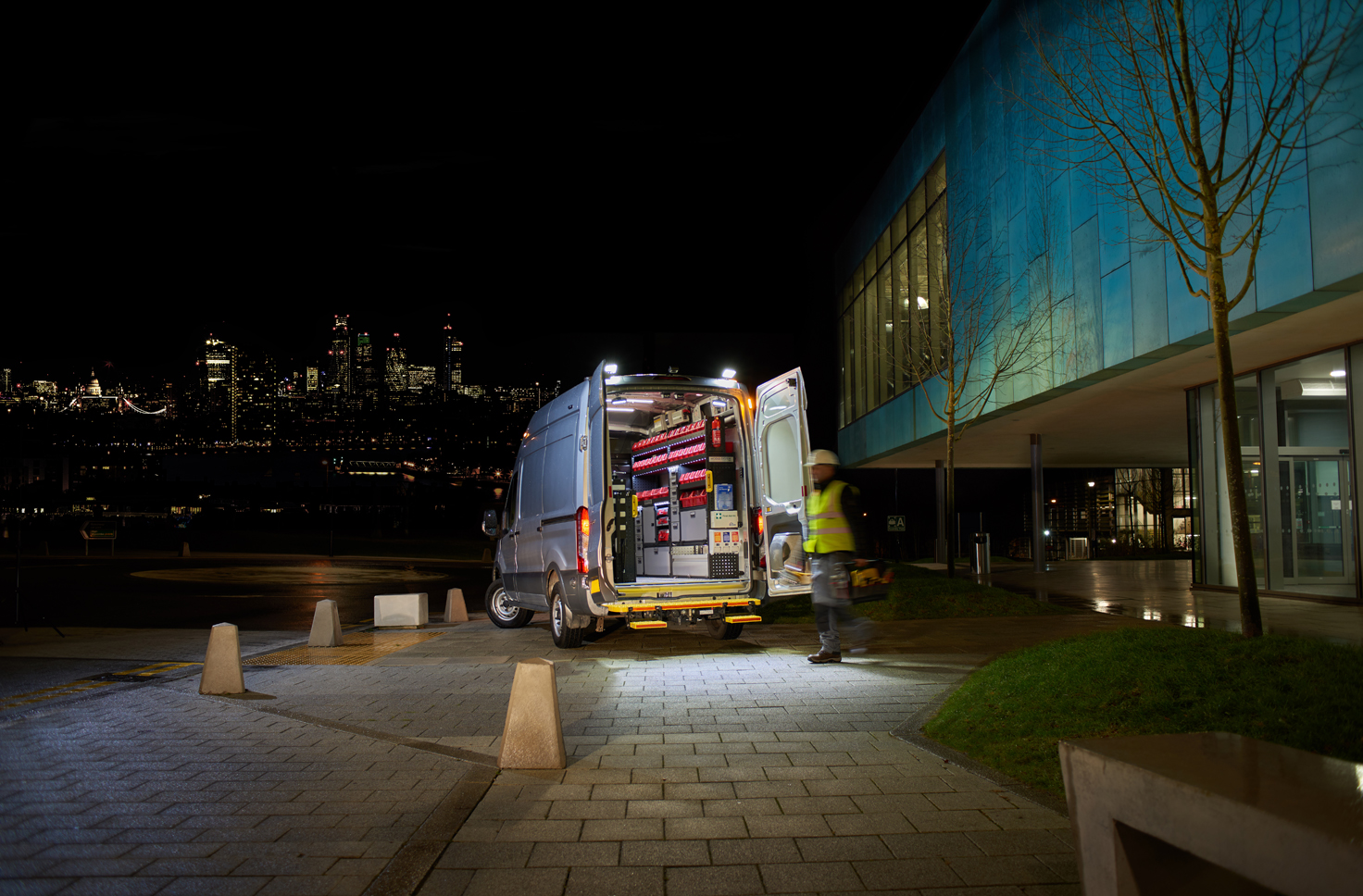 Electrician's van fitted out with modul-system van racking on the job at night