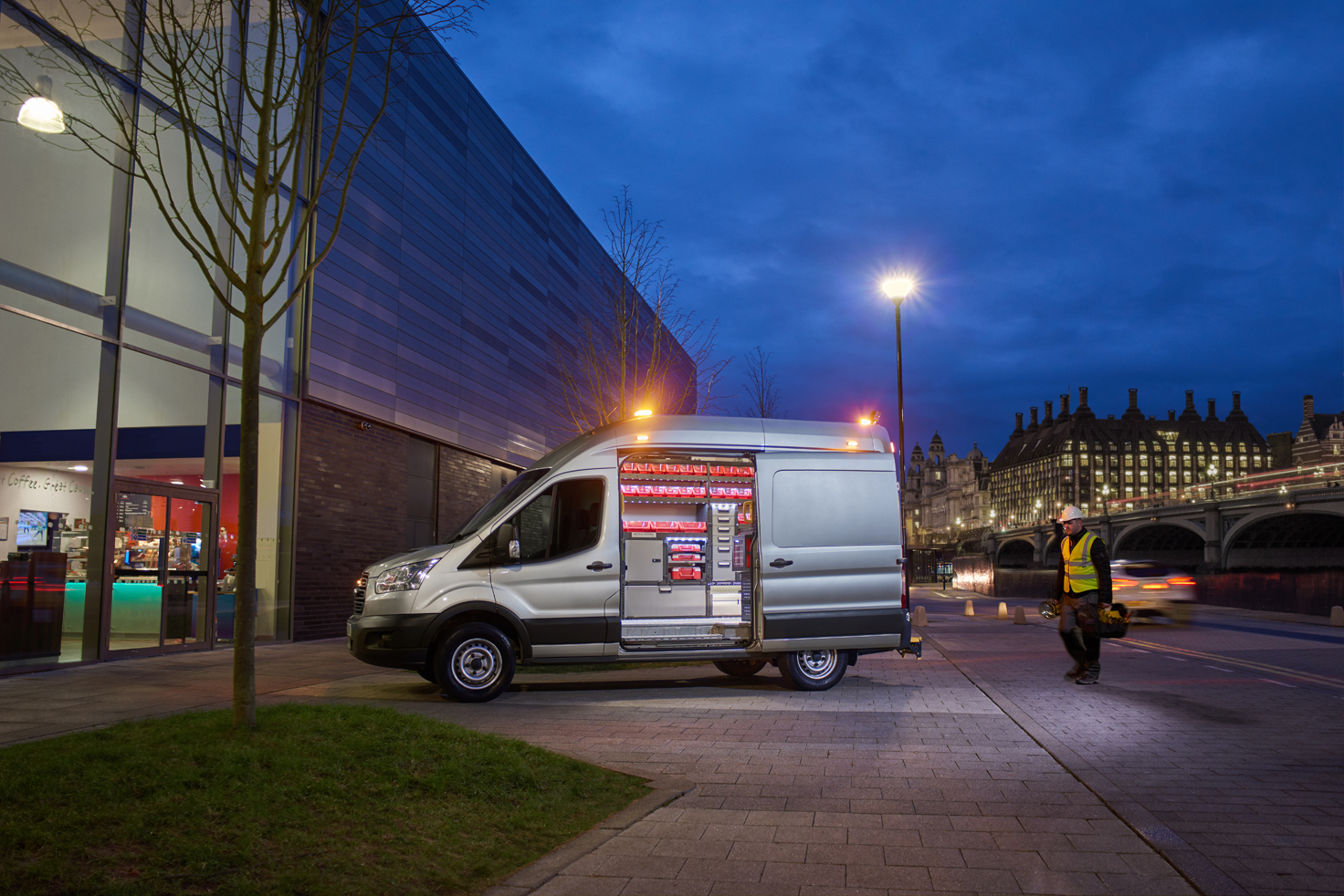 Electrician's van fitted out with modul-system van racking on the job at night